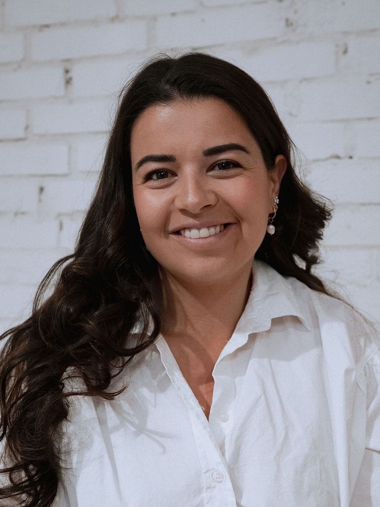 Larissa De Martin vor einer weiss gestrichenen Backsteinwand
