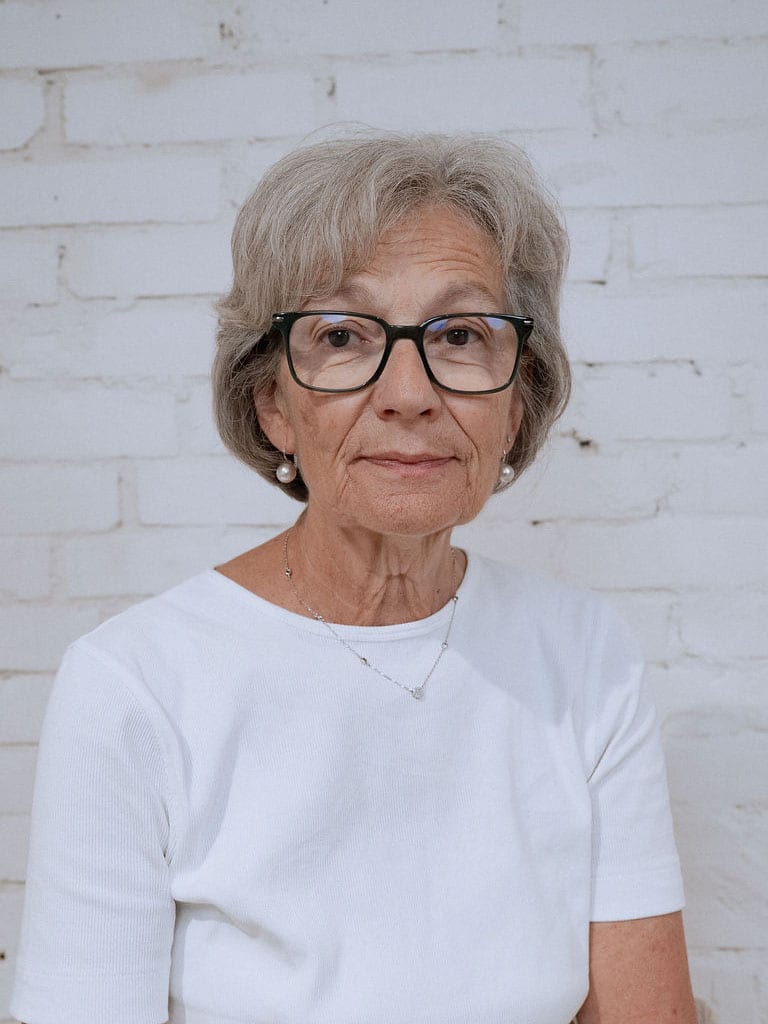 Ruth Hartmann vor einer weiss gestrichenen Backsteinwand
